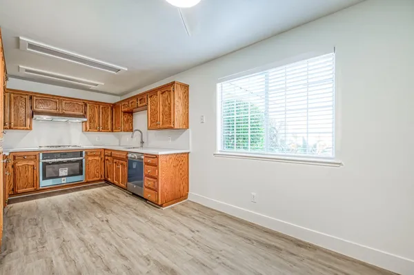 a kitchen with stainless steel appliances granite countertop a stove a sink and wooden floors