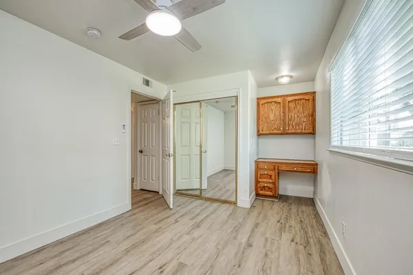 a view of a hardwood floor and a ceiling fan in a room