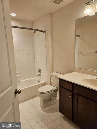 a bathroom with a sink a toilet a mirror a bathtub and shower