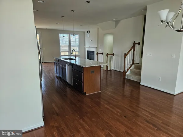 a kitchen with stainless steel appliances granite countertop a sink and wooden floor