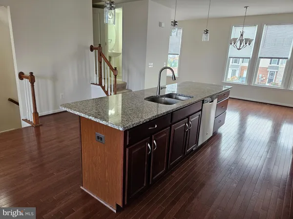 a kitchen with a sink cabinets and wooden floor