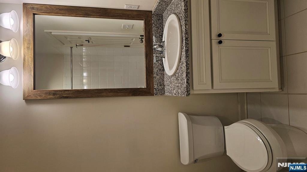 188 Aspen Drive, Unit 414 Cedar Grove, NJ 07009 - Photo 12 of 23 a bathroom with a granite countertop toilet and a sink
