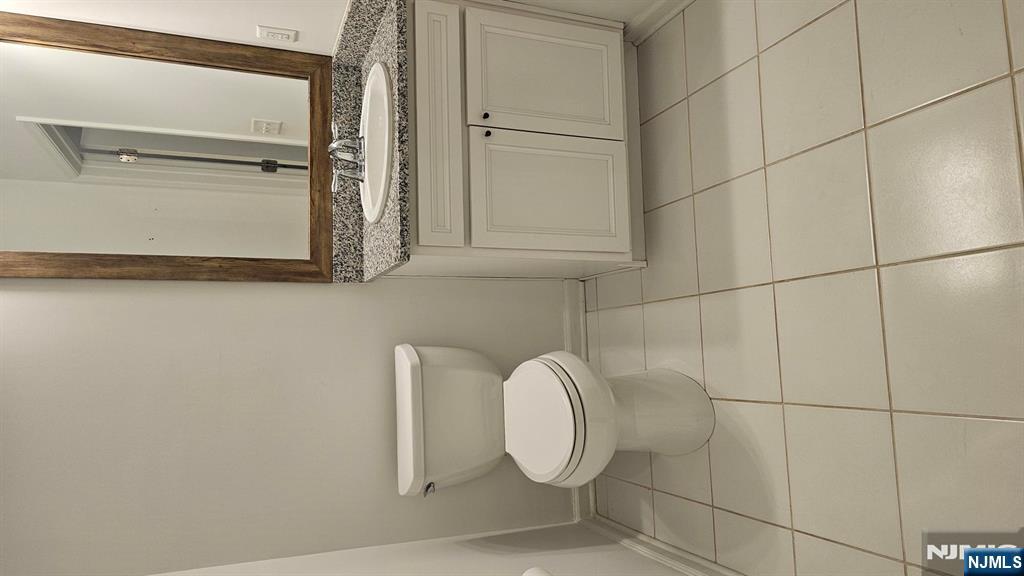 188 Aspen Drive, Unit 414 Cedar Grove, NJ 07009 - Photo 14 of 23 a bathroom with a granite countertop toilet and a sink