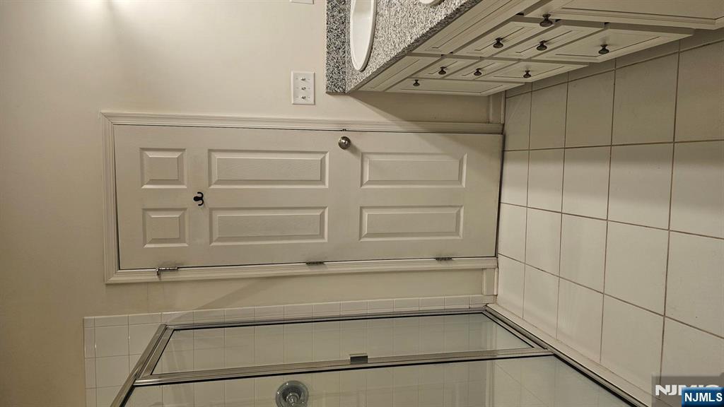 188 Aspen Drive, Unit 414 Cedar Grove, NJ 07009 - Photo 15 of 23 a bathroom with a granite countertop sink a mirror and a shower