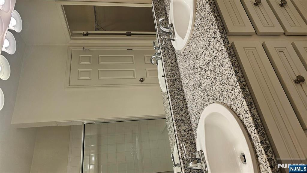 188 Aspen Drive, Unit 414 Cedar Grove, NJ 07009 - Photo 16 of 23 a bathroom with a granite countertop sink and a mirror