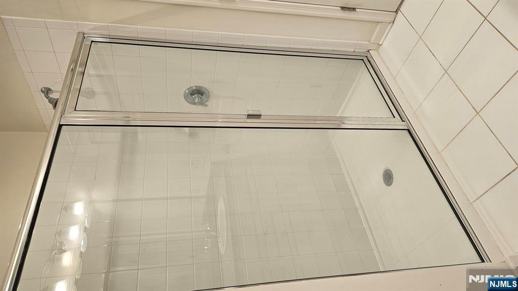 188 Aspen Drive, Unit 414 Cedar Grove, NJ 07009 - Photo 17 of 23 a bathroom with a glass shower door