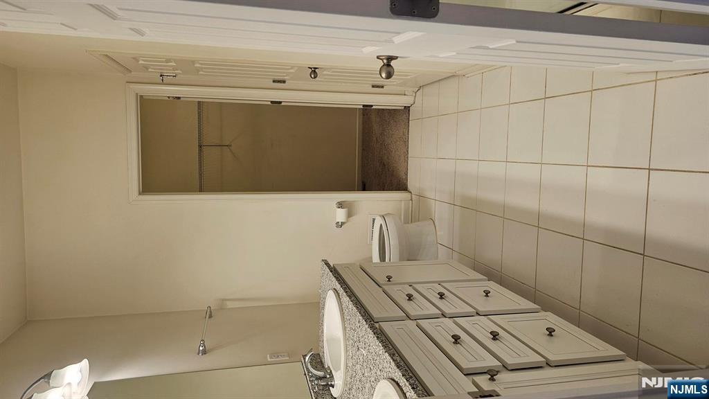 188 Aspen Drive, Unit 414 Cedar Grove, NJ 07009 - Photo 18 of 23 a spacious bathroom with a granite countertop sink a toilet and mirror