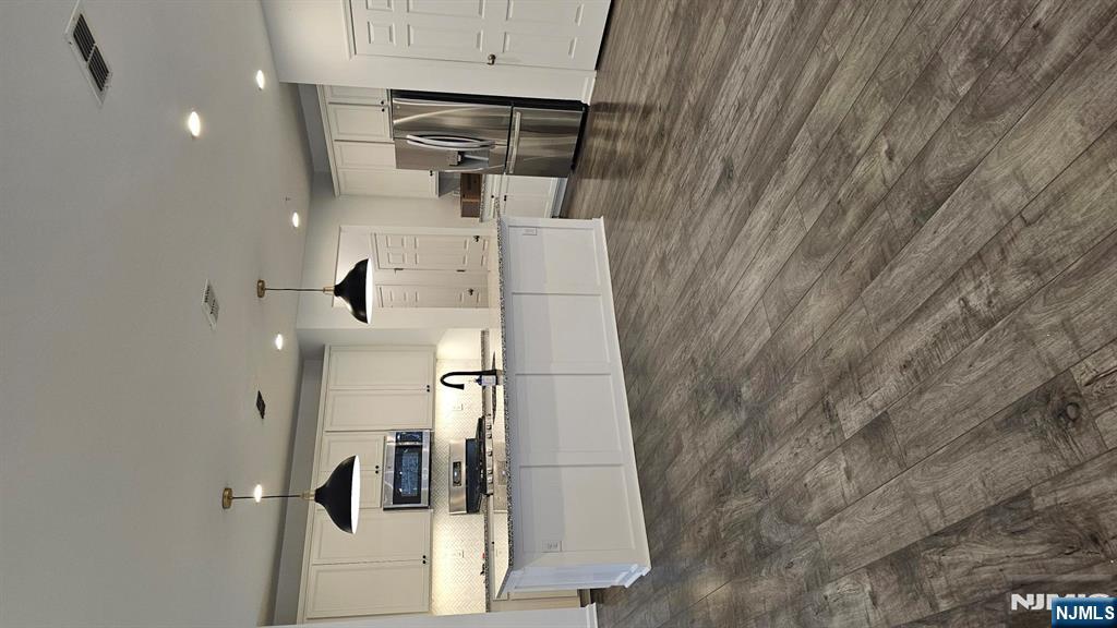 188 Aspen Drive, Unit 414 Cedar Grove, NJ 07009 - Photo 2 of 23 a large kitchen with stainless steel appliances kitchen island a large counter top and a stove