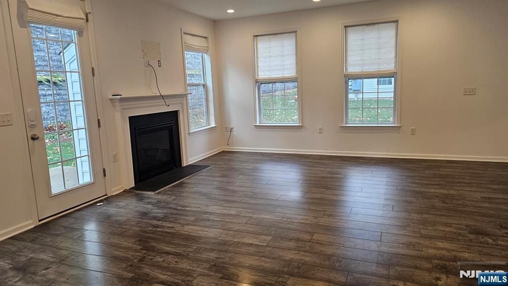 188 Aspen Drive, Unit 414 Cedar Grove, NJ 07009 - Photo 7 of 23 an empty room with wooden floor fireplace and windows