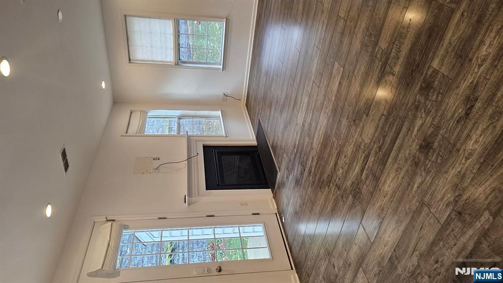 188 Aspen Drive, Unit 414 Cedar Grove, NJ 07009 - Photo 8 of 23 an empty room with windows fireplace and wooden floor