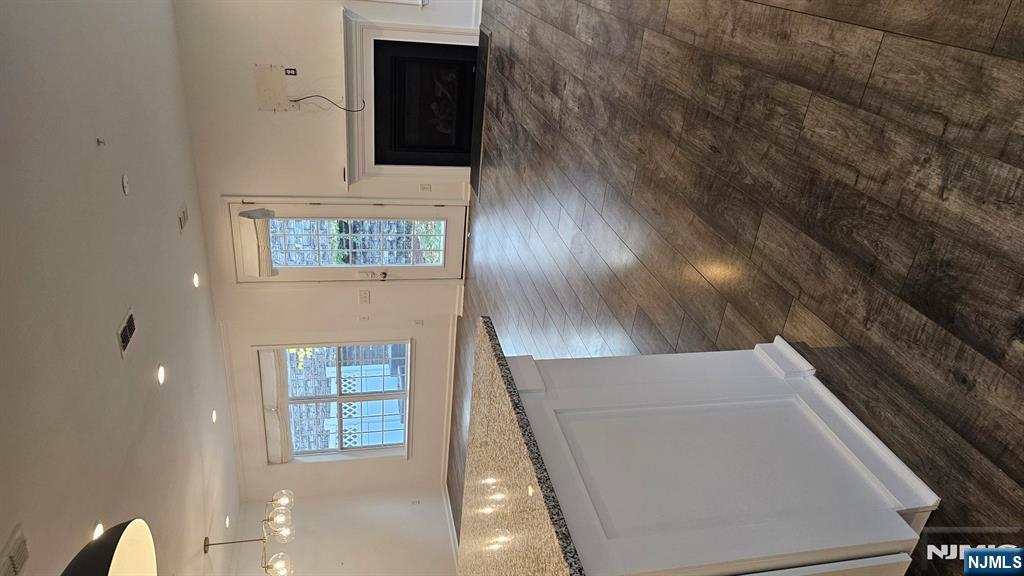 188 Aspen Drive, Unit 414 Cedar Grove, NJ 07009 - Photo 9 of 23 a kitchen with granite countertop a stove and a wooden floor