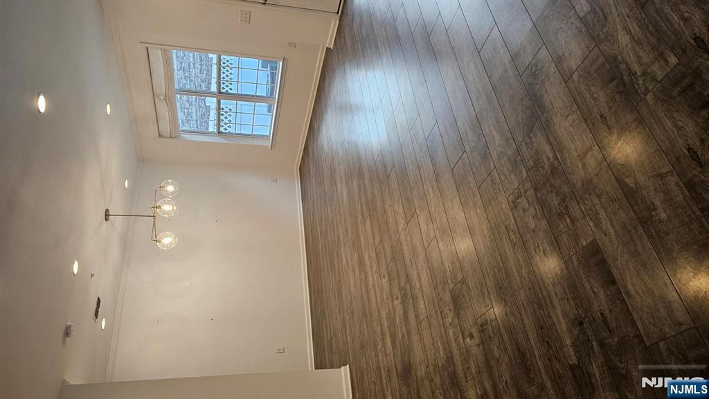188 Aspen Drive, Unit 414 Cedar Grove, NJ 07009 - Photo 10 of 23 an empty room with wooden floor and windows