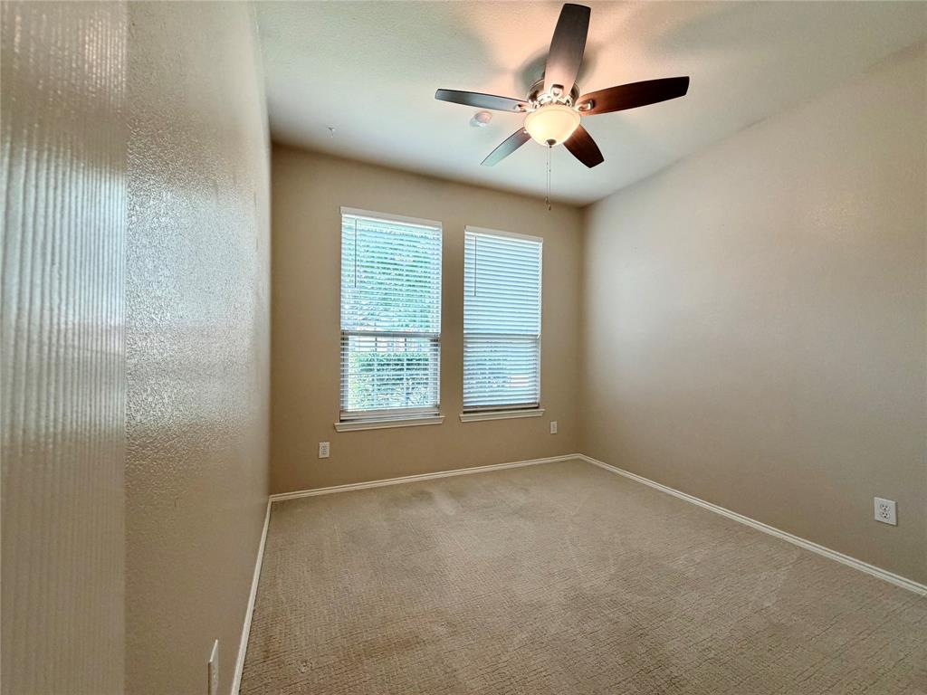 5817 Deck House Road Fort Worth, TX 76179 - Photo 13 of 19 Room with neutral tone walls and carpeting, featuring a vaulted ceiling and a ceiling fan with light fixture