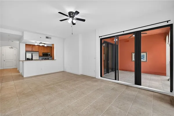 an empty room with fan and windows