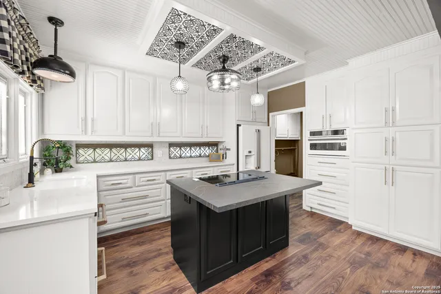 a kitchen with a sink a stove and cabinets