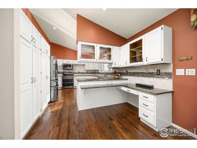 a kitchen with stainless steel appliances a stove a sink dishwasher and cabinets with wooden floor