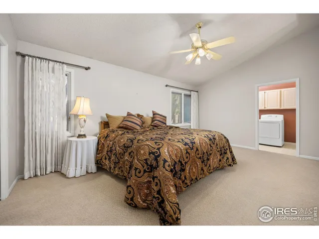 a bed sitting in a spacious bedroom next to a window