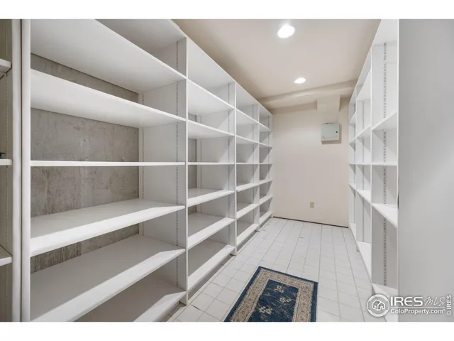 a view of an empty room with wooden floor and staircase