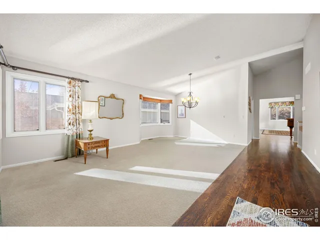 a living room with furniture and a dining table with wooden floor