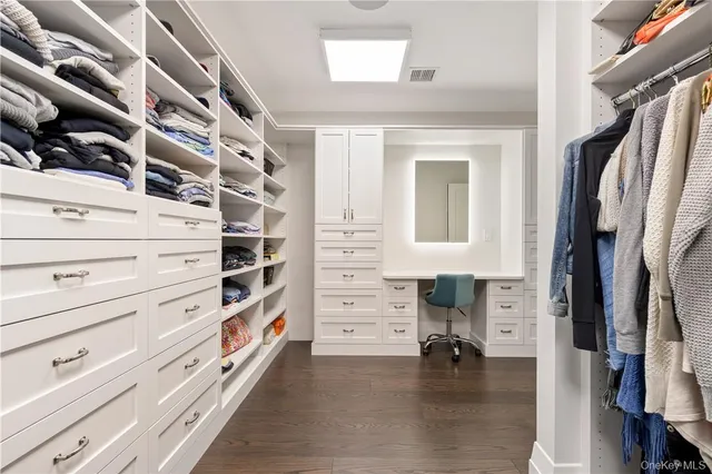 a view of walk in closet with clothes and shoes
