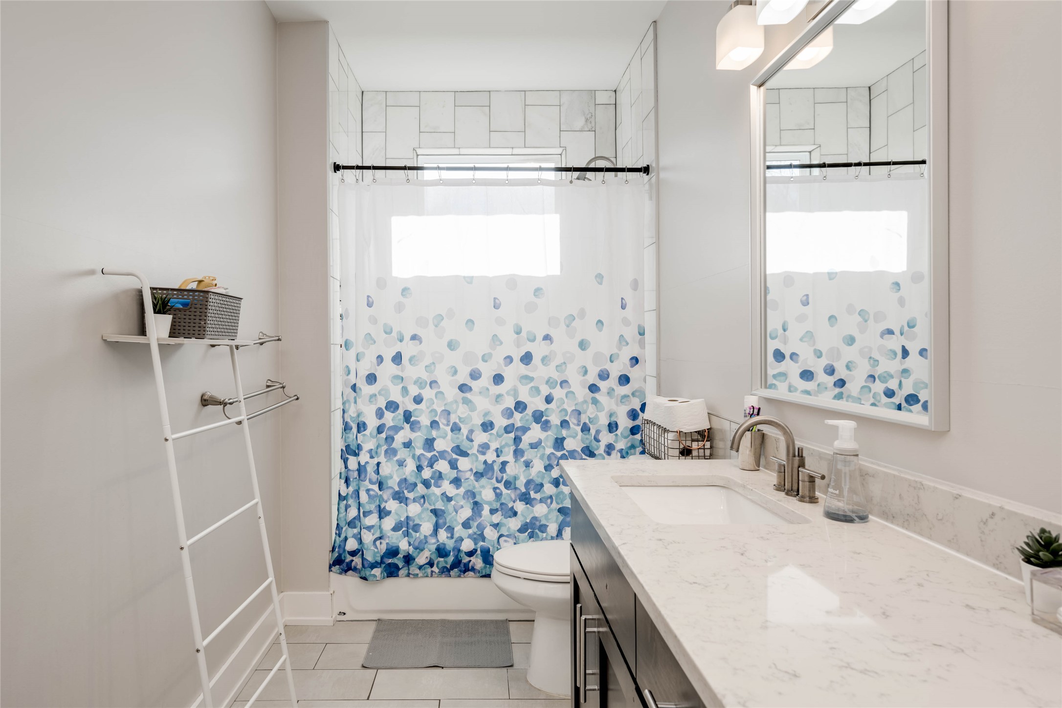 7514 Hardy Drive Austin, TX 78757 - Photo 16 of 29 Full bathroom with vanity, plenty of natural light, and light tile patterned floors