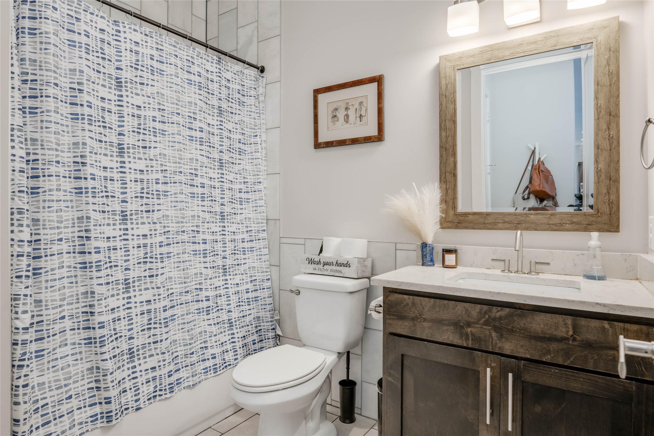 7514 Hardy Drive Austin, TX 78757 - Photo 17 of 29 Bathroom with vanity, shower / bath combo with shower curtain, tile walls, and light tile patterned floors