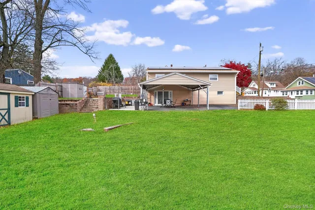 a view of a house with a yard and sitting area