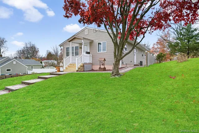 a front view of a house with a yard and trees