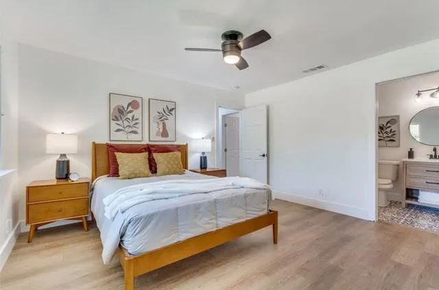 a bathroom with a toilet sink vanity and shower