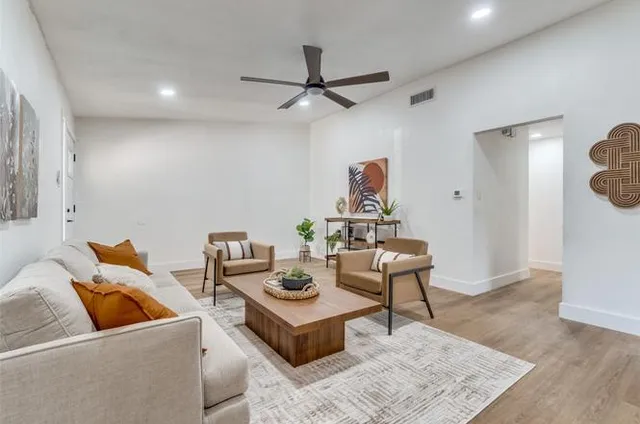 a living room with furniture and a wooden floor