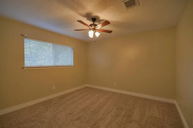 a view of a room with a ceiling fan and a window