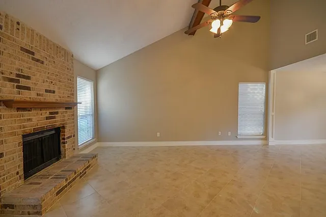 en empty room with windows and fireplace