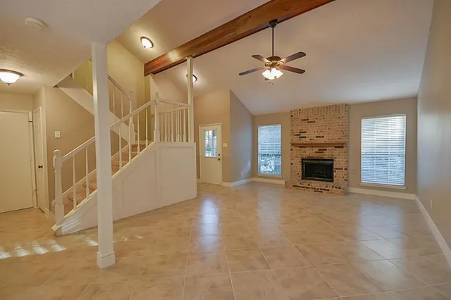 a view of a livingroom with a fireplace and a ceiling fan