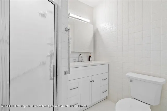 a bathroom with a toilet a sink a mirror and vanity