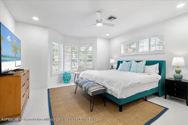 a bedroom with a bed window and a flat screen television