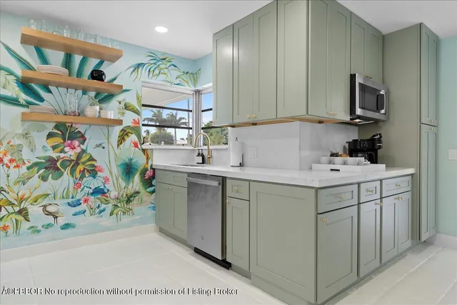 a kitchen with stainless steel appliances a sink a microwave a refrigerator and window