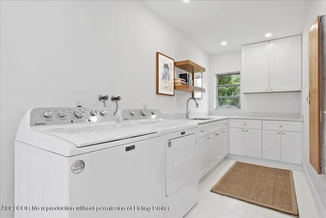 a utility room with cabinets washer and dryer