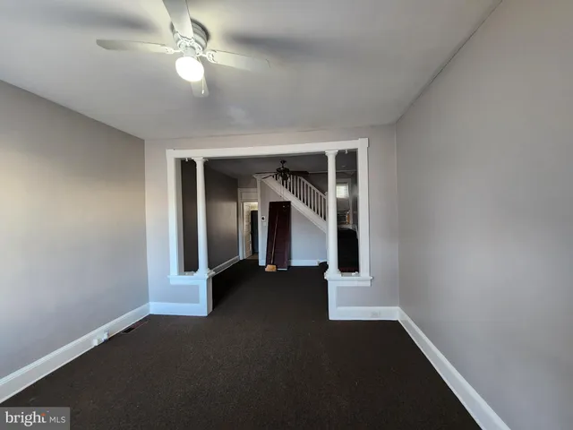 a view of a livingroom with wooden floor and a ceiling fan