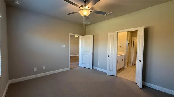 an empty room with closet and a chandelier fan