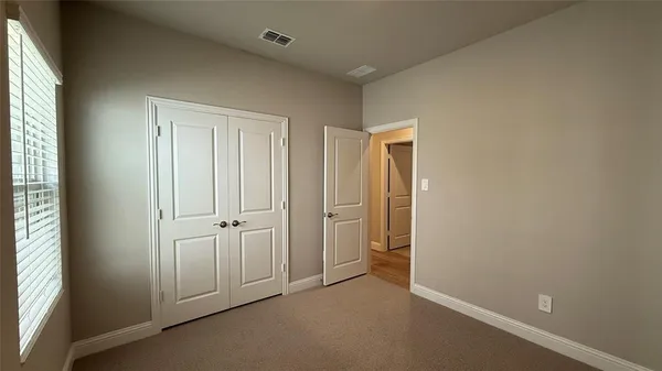 an empty room with windows and closet
