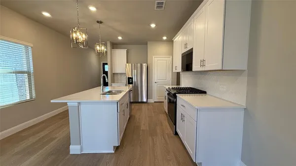 a kitchen with stainless steel appliances granite countertop a sink stove and refrigerator