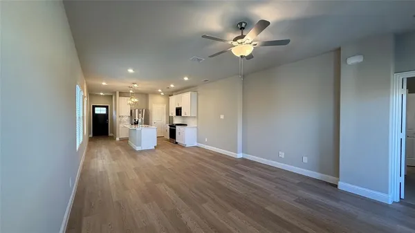 a view of a hallway with wooden floor and a large window