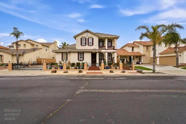 a front view of a building with a garden and a car