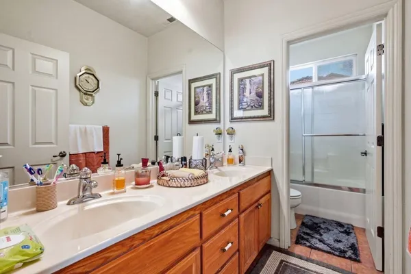 a bathroom with double vanity sink a mirror and a shower