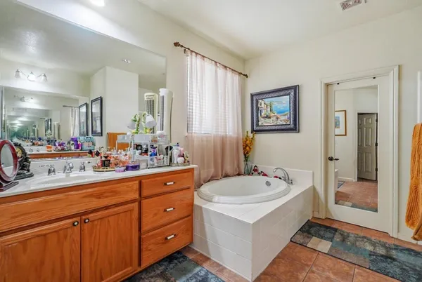 a spacious bathroom with a tub sink and mirror