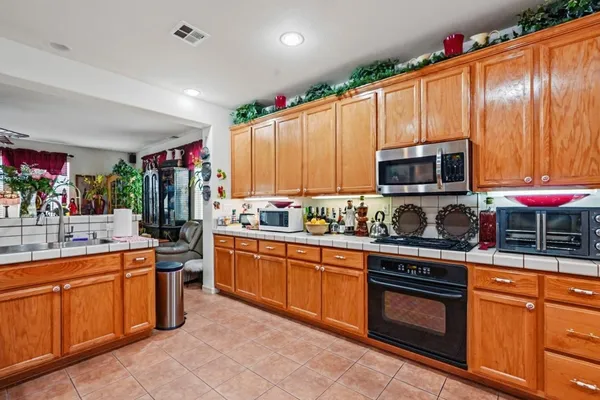 a kitchen with stainless steel appliances granite countertop wooden cabinets and a stove