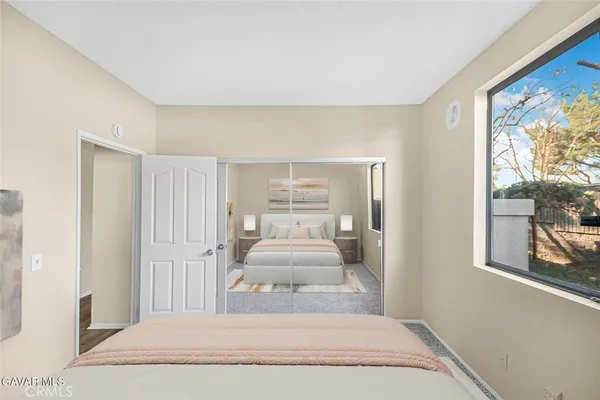 a view of a bedroom with wooden floor and furniture