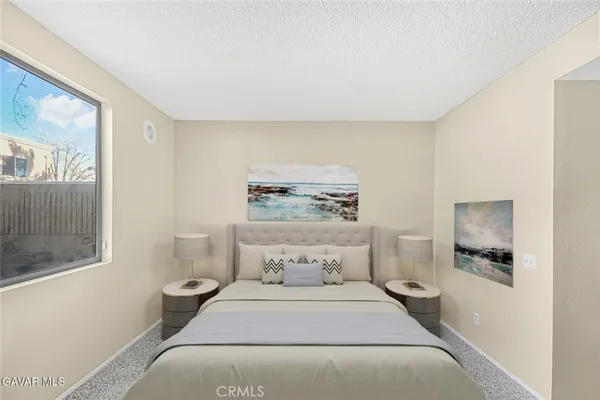 a spacious bedroom with a bed and a painting on the wall