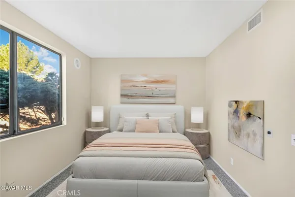 a bedroom with a large bed and a painting on the wall