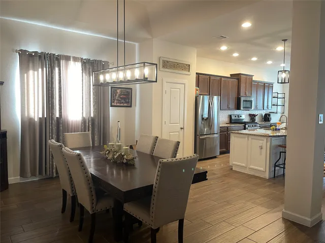a kitchen with refrigerator cabinets dining table and chairs
